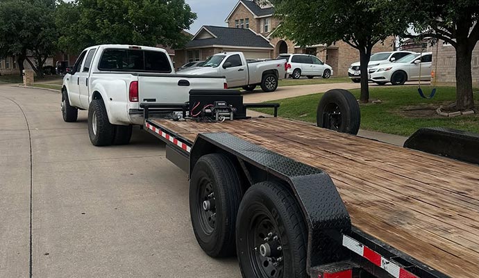 102 inch wide 40ft gooseneck trailer being hauled by a white pickup truck