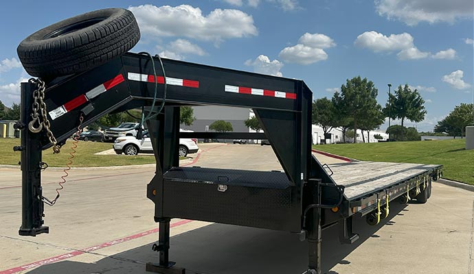 102 x 40 gooseneck trailer with spare tire parked on pavement
