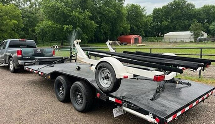 A flatbed trailer attached to a pickup truck, prepared for fast, short-notice hot shot cargo delivery.