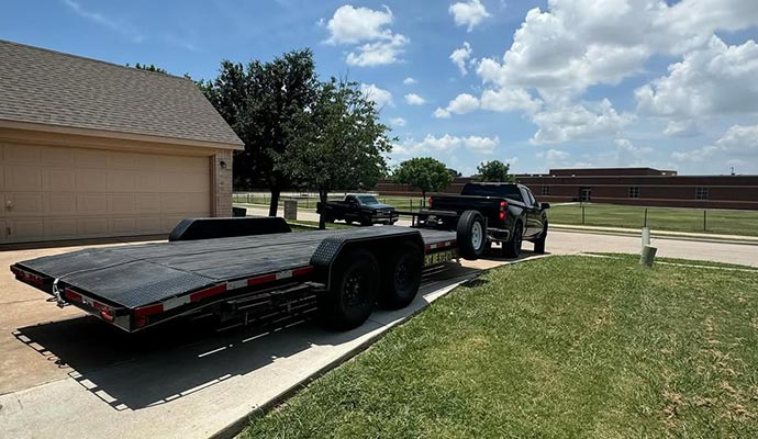 A flatbed trailer parked in a residential driveway