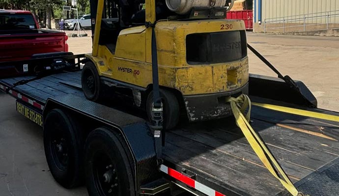 Forklift loaded on flatbed trailer